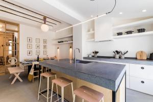 - une cuisine avec un grand comptoir et des tabourets dans l'établissement PAMPA  KEYWEEK Maison de ville terrasse Biarritz Beaurivage, à Biarritz
