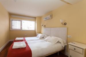 a bedroom with a bed with two towels on it at Las Casas de Moratin in Seville