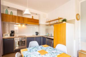 uma cozinha com armários azuis e uma mesa com cadeiras em Apartament Scandi em Gdynia