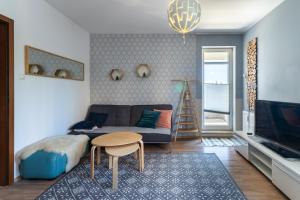 uma sala de estar com um sofá, uma mesa e uma televisão em Apartament Scandi em Gdynia