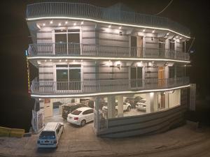 a building with cars parked in a parking lot at night at City Seasons Hotel Murree in Murree