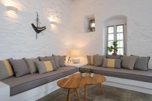 a living room with a couch and a table at NIREAS STONEHOUSE IN APOLLONIA SIFNOS in Sifnos