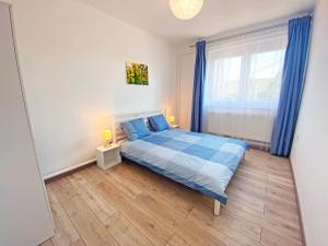 a bedroom with a blue bed and a window at Vizililiom Vendégház in Tiszafüred