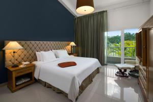 een slaapkamer met een groot wit bed en een raam bij Hodelpa Garden Suites - All Inclusive in Juan Dolio