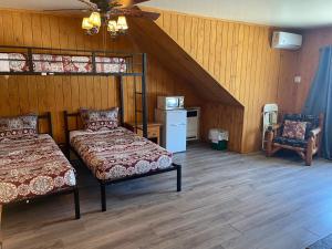 a attic bedroom with two beds and a chair at Bear Creek Resort in Big Bear Lake