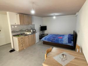 a kitchen and a bedroom with a bed and a table at Apartmani Mihajlović in Herceg-Novi