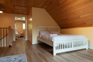Cama en habitación con techo de madera en Bear Valley Highlands en Lumby