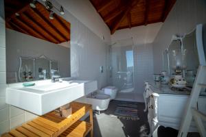 uma casa de banho branca com um lavatório e um WC em aMaRe Country House em Caminha