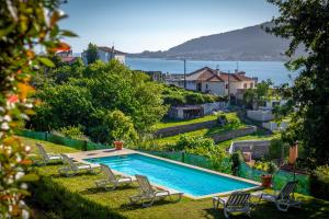 uma piscina num quintal com cadeiras e água em aMaRe Country House em Caminha