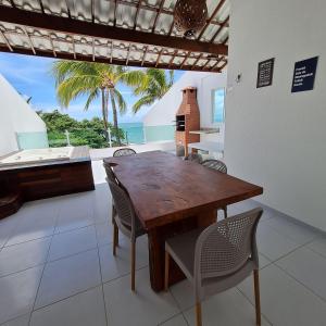 a dining room with a table and chairs and the ocean at Maria Farinha Residence Prince - LocarHouse in Maria Farinha