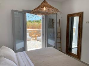 Un dormitorio con una cama y vista a un patio. en Beachhouse Omega Naxos, en Agia Anna de Naxos