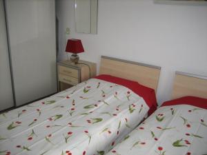 a bedroom with two beds and a red lamp at B&B Ans en Ben Streppel in Twello