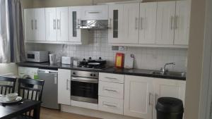 a kitchen with white cabinets and a sink and a stove at Marble Arch Flats in London +13 photos