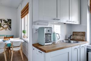 a kitchen with a sink and a microwave at Downtown apartment with views over city rooftops in Turku