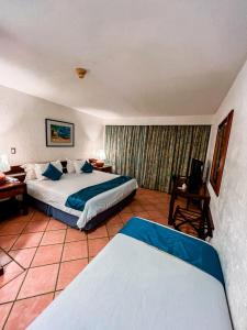 Hotel California Playa El Yaque tesisinde bir odada yatak veya yataklar