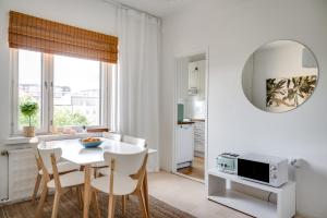 a kitchen and dining room with a white table and chairs at Downtown apartment with views over city rooftops in Turku