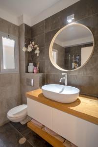 ein Badezimmer mit einem Waschbecken, einem WC und einem Spiegel in der Unterkunft Ashdod on the sea- אשדוד על הים in Aschdod
