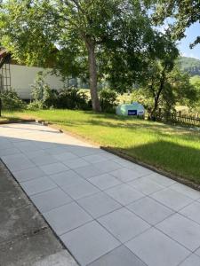 einen Gehweg vor einem Hof mit einem Baum in der Unterkunft Ferienwohnung im Zeegenbachtal in Strullendorf