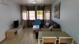 salon z kanapą i stołem w obiekcie Atractivo apartamento en la playa con parking w mieście Roquetas de Mar