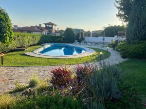 a swimming pool in the middle of a garden at Family Hotel Dreams in Sozopol