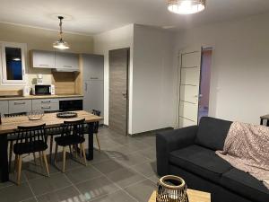 a kitchen and a living room with a couch and a table at Résidence Pasturella in Bastia