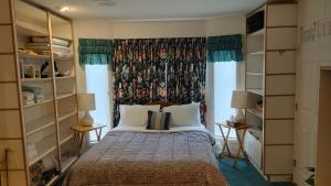 a bedroom with a bed with a window and shelves at Beds By the Bridge in Kelowna