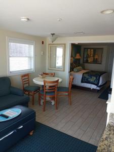 a living room with a bed and a table and chairs at Ocean Club on Smuggler's Beach in South Yarmouth