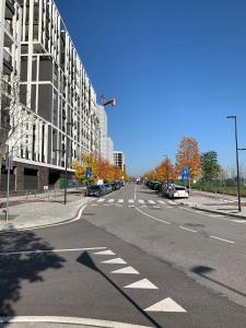 an empty street with cars parked on the side of a building at Sweet Home in Milano smart district in Milan