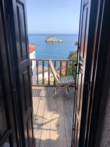 une porte ouverte s'ouvrant sur un balcon avec vue sur l'océan. dans l'établissement Blaue Welle Haus, à Parga