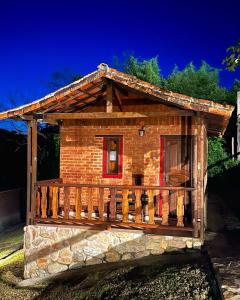 drewniany domek z werandą i tarasem w obiekcie Chalés Ouro de Minas w mieście Conceição da Ibitipoca