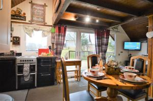 a kitchen with a table and a kitchen with a stove at Iona Lodge in Dalavich