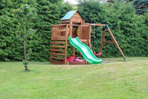 a playground with a slide in the grass at Penzion a Restaurace U Paseků in Harrachov