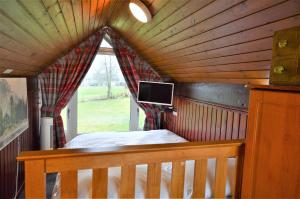 a bedroom with a bed and a window with a tv at Iona Lodge in Dallavich