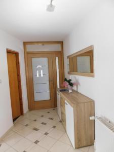 a kitchen with a refrigerator and a door in a room at Apartman Lara in Otočac