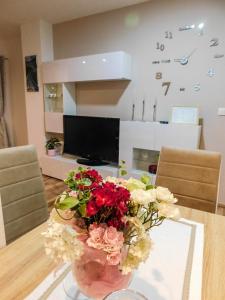 a dining room table with a vase of flowers on it at Apartman Lara in Otočac