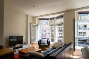 a living room with a couch and a television at Maligima in De Panne