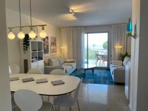ein Wohnzimmer mit einem weißen Tisch und Stühlen in der Unterkunft EPIS - large luxury apartment with sea view in Benicàssim