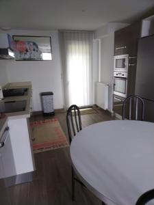 una cucina con tavolo e sedie in una stanza di ANGLET petite Maison à 2 kms des plages et de Biarritz ad Anglet