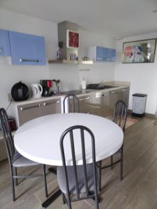 - une cuisine avec une table blanche et des chaises dans l'établissement ANGLET petite Maison à 2 kms des plages et de Biarritz, à Anglet