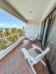 uma varanda com 2 espreguiçadeiras e uma mesa em Hotel California Playa El Yaque em El Yaque
