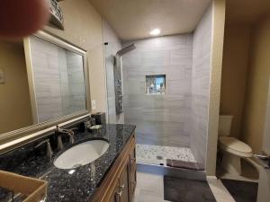 uma casa de banho com um lavatório, um chuveiro e um WC. em Dream house with capacity of 23 people em Fort Walton Beach