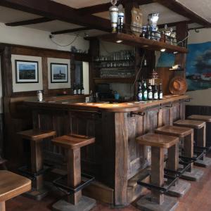 um bar de madeira com bancos num quarto em Gasthof Feische em Hellefeld