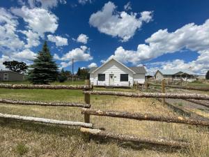 a white house behind a fence in a field at Callie's Cottage in Hatch