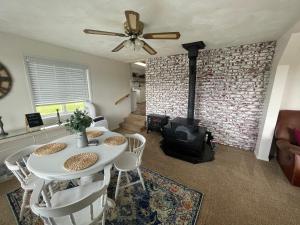 a living room with a table and a fireplace at Callie's Cottage in Hatch