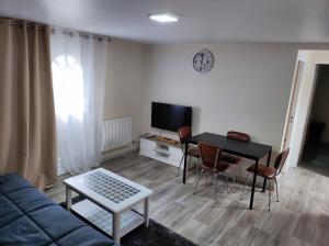 a living room with a couch and a table and a tv at kaon nil in Gerzat