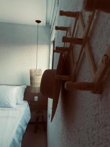 - une chambre avec un lit et une échelle sur le mur dans l'établissement 7 ESTRELAS PATACHO, à Porto de Pedras