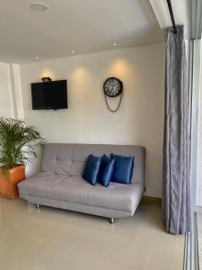 a couch with blue pillows in a living room at Hermoso Apartasol San Jeronimo in San Jerónimo