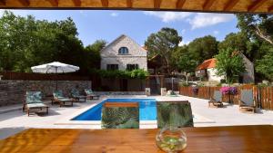 a backyard with a swimming pool and a house at Traditional villa Juta for 8 people in Hrvace