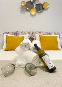 a bed with towels and a bottle of wine and glasses at Gerani Deluxe Houses 2 in Astypalaia Town