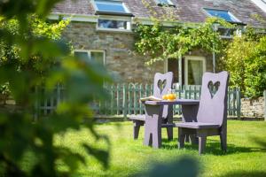 a table and chairs in the yard of a house at Y Ffermdy Farmhouse in Sarnau
